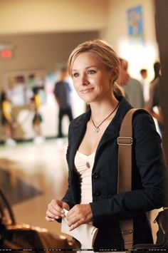 a woman is standing in an airport with her hand on her hip and looking at the camera