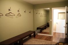 a hallway with coat racks, benches and mirrors on the wall next to each other