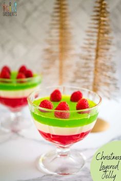 christmas layered jello with raspberries and whipped cream in small glasses on a table