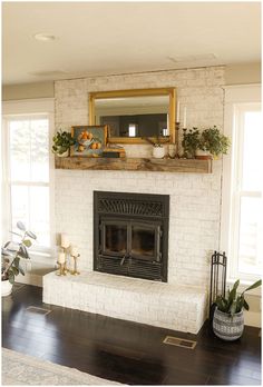 a living room with a white brick fireplace and wooden mantle, potted plants on the mantel