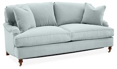 a light blue couch with two pillows on it's back and one arm facing the camera