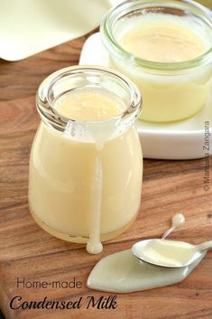 two jars of homemade condiments on a cutting board with spoons next to them