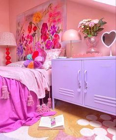 a bedroom with pink walls and flowers on the headboard is decorated in bright colors