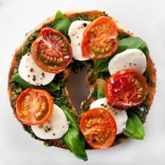 an open face sandwich with tomatoes, mozzarella and spinach leaves on it