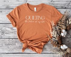 an orange t - shirt that says quilting the future of my life on it