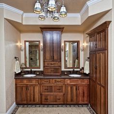 a large bathroom with double sinks and wooden cabinets