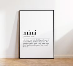 a white framed poster with the words mimi on it in front of a wooden floor