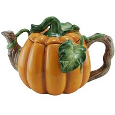 a ceramic pumpkin shaped teapot with leaves on it