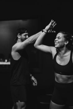 black and white photograph of two people dancing in front of a man with his arm raised