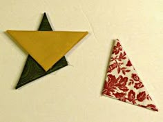 two pieces of folded fabric sit next to each other on a white surface with red and green designs