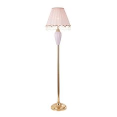 a floor lamp with a pink shade on the base and a gold plated base