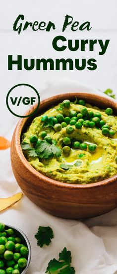 a wooden bowl filled with guacamole surrounded by peas and cilantro