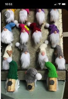 several knitted gnomes are hanging on a wall