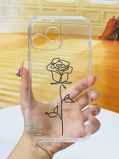 a hand holding up a clear phone case with a drawing of a rose on it