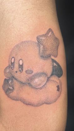 a small tattoo on the leg of a person with a teddy bear sitting on top of it