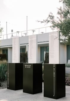 three black boxes sitting in front of a building