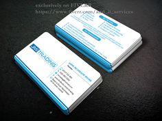 two blue and white business cards sitting on top of a black surface with the same logo