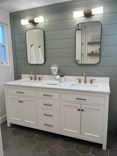 a bathroom with two sinks and mirrors on the wall