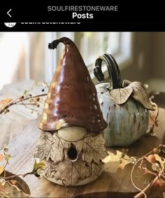 two small ceramic pumpkins sitting on top of a wooden table next to each other