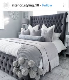 the bed is made up with grey and white sheets, pillows, and teddy bears