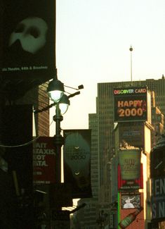 there are many billboards in the city with buildings behind them and one is advertising happy new year