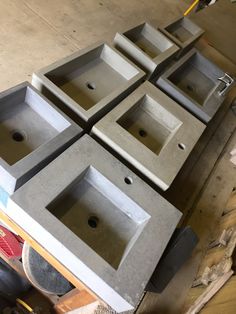 four concrete sinks sitting on top of each other in a room with construction materials around them