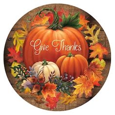 a wooden plaque with pumpkins and leaves on it that says give thanks to all of us