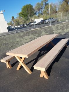 two wooden benches sitting in the middle of a parking lot