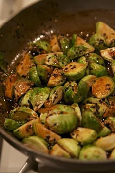 brussel sprouts are being cooked in a skillet on the stove