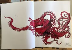 an open book with red octopus drawings on it