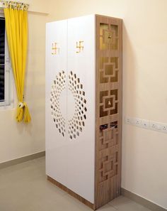 a white cabinet sitting in the middle of a room next to a yellow drapes