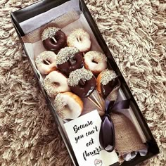 a box filled with donuts sitting on top of a carpet