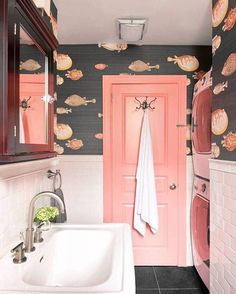 a bathroom with a sink, mirror and pink door