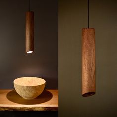 two wooden lights hanging from the ceiling above a bowl