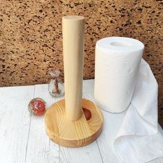 two rolls of toilet paper and a wooden holder on a white table with marbles