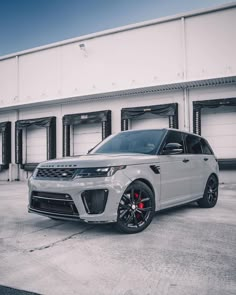 a white range rover parked in front of a building