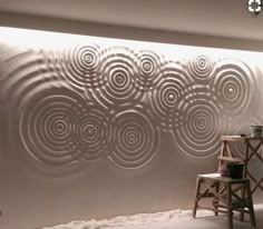 a room with a chair and a wall made out of metal circles on it's side