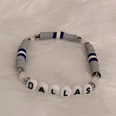 a beaded bracelet with the word dallas written in black and white beads on it