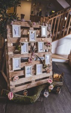 a clock made out of wooden pallets with pictures on it and flowers around the frame