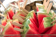 slices of watermelon and toothpicks in a bowl with sticks sticking out of them