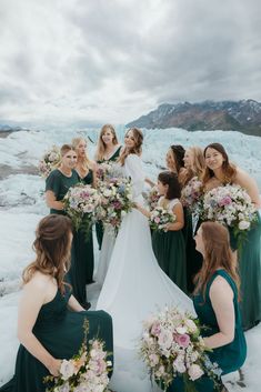 a group of women standing next to each other in front of some snow covered ground