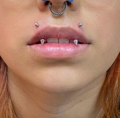 a woman with piercings on her nose and nose ring in front of her face