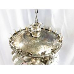 a metal tray with silver decorations on it and a chandelier hanging from the ceiling