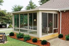 a screened in porch with landscaping around it