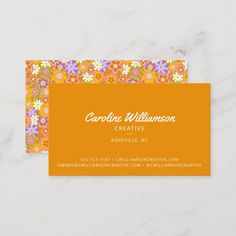 an orange business card with colorful flowers on the front and bottom, along with a white marble background