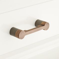 a close up of a door handle on a white cabinet with wood handles and knobs