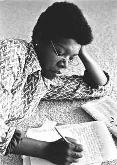 a woman sitting on the floor with her head in her hands and reading a book