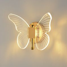 a light that is on the wall with a butterfly shaped light in front of it