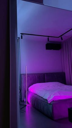 there is a bed with purple lights in the room