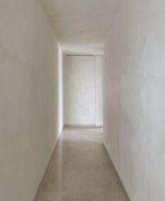 an empty hallway with white walls and floor